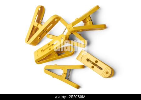 pile of yellow clips, plastic paper or laundry clips, clothespin or clothes pegs isolated on white background taken straight from above Stock Photo