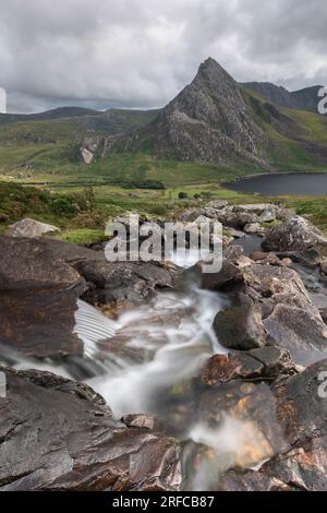 River cascading over rocks Afon Lloer, looking across to Tryfan, Snowdonia National Park, Wales Stock Photo