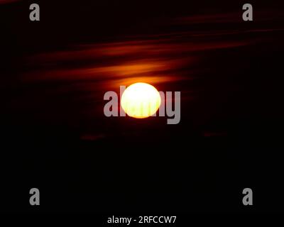 The disk of the northern rising sun on a sultry, damp midsummer day. Gloomy morning twilight. "Martian sun" Stock Photo