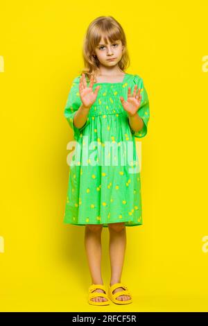 Hey you, be careful. Blonde child girl kid warning with admonishing finger gesture, saying no, be careful, scolding and giving advice to avoid danger, disapproval sign. Preteen children. Vertical Stock Photo