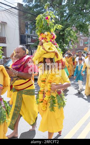 A pandita preistess marches from her temple to the site of the Thimithi fire walking ritual with an ornate statue of a deity. In Richmond Hill, Queens Stock Photo