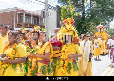 A pandita preistess marches from her temple to the site of the Thimithi fire walking ritual with an ornate statue of a deity. In Richmond Hill, Queens. Stock Photo