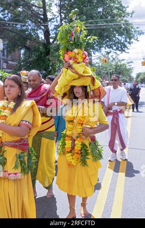 A pandita preistess marches from her temple to the site of the Thimithi fire walking ritual with an ornate statue of a deity. In Richmond Hill, Queens. Stock Photo