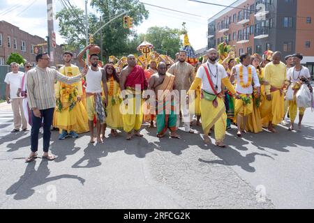 A group of devout HIndus dressed in ethnic clothing march from their temple in Ozone Park to the Arya Spiritual Grounds for a Fire Walking service. Stock Photo