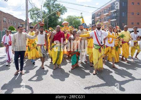 A group of devout HIndus dressed in ethnic clothing march from their temple in Ozone Park to the Arya Spiritual Grounds for a Fire Walking service. Stock Photo