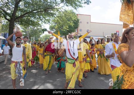 A group of devout HIndus dressed in ethnic clothing march from their temple in Ozone Park to the Arya Spiritual Grounds for a Fire Walking service. Stock Photo