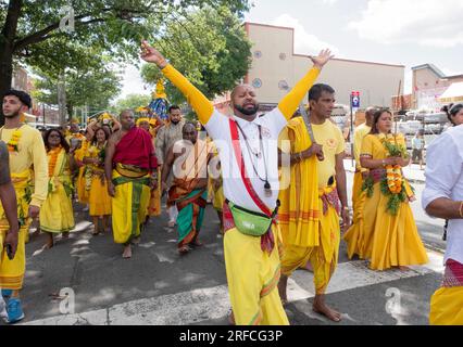 A group of devout HIndus dressed in ethnic clothing march from their temple in Ozone Park to the Arya Spiritual Grounds for a Fire Walking service. Stock Photo