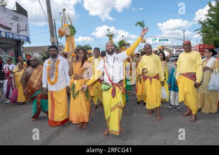 A group of devout HIndus dressed in ethnic clothing march from their temple in Ozone Park to the Arya Spiritual Grounds for a Fire Walking service. Stock Photo