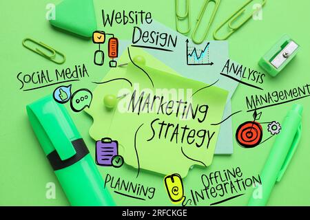 Sticky notes with written components of business strategy and stationery on green background Stock Photo