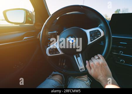 BMW G30 5-series M-package steering wheel. Woman is holding sport fast car steering wheel. 13.05.2023 Tallinn, Estonia Stock Photo