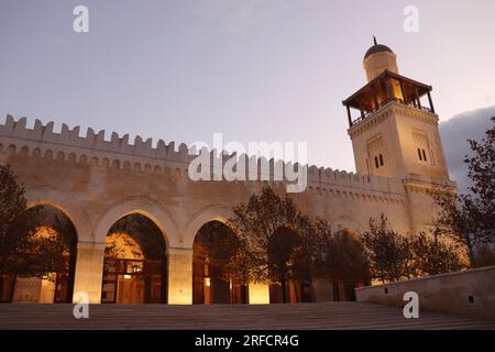 Arab Islamic mosque in Amman, Jordan - minaret, yellow lights, trees in autumn (King Hussein Bin Talal Mosque) Stock Photo