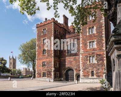 Lambeth Palace London. Morton's Tower with Houses of Parliament behind. Red brick Tudor gatehouse forming the entrance to Lambeth Palace London UK Stock Photo