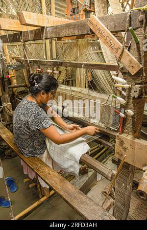 Woman weaving silk on a loom in Sualkuchi, a small town in Assam which is the centre of the silk weaving industry. Stock Photo