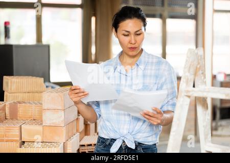 Woman making notes at renovating house Stock Photo