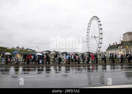 London, UK. 2nd Aug, 2023. People brave the rain on Westminster Bridge in London, Britain, on Aug. 2, 2023. A yellow alert for storms stretching from London to Manchester and covering much of the Midlands and Wales was issued by the Met Office on Wednesday. Credit: Xinhua/Alamy Live News Stock Photo