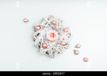 Christmas wreath with pink candle and balls on silver gray background. Winter holidays concept. Top view, flat lay. Stock Photo