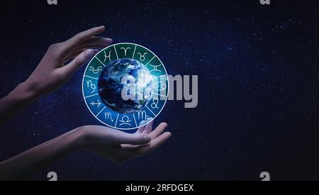 Woman holding illustration of Earth with zodiac wheel around it in open space, closeup Stock Photo