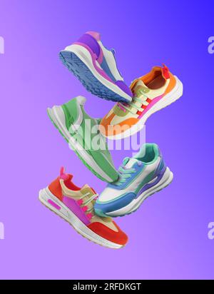 Different sneakers falling on blue gradient background Stock Photo