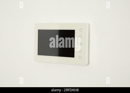 Modern video intercom hanging on white wall Stock Photo