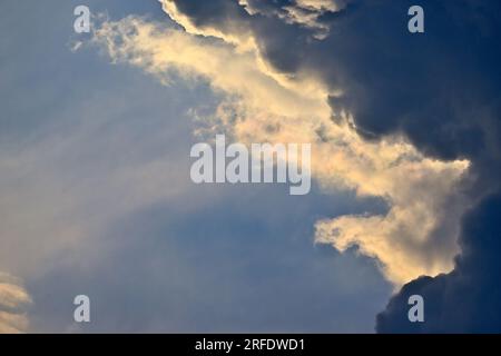 A backlit storm cloud in the evening sky in rural Alberta Canada Stock Photo