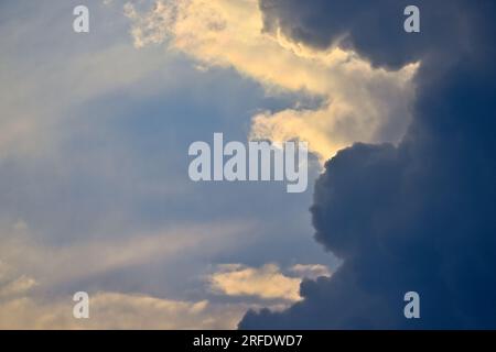 A backlit storm cloud in the evening sky in rural Alberta Canada Stock Photo