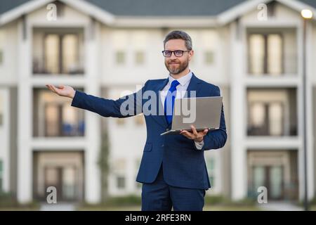Man working on laptop outdoor. Man checking email on laptop, writing message in social network, using internet, searching information on laptops ousid Stock Photo
