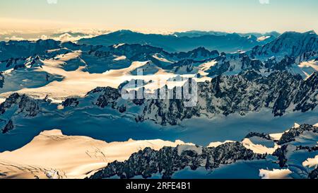 Flying  over the tallest snow covered peaks of the Southern alps in a helicopter with no windows Stock Photo