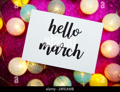 Hello March text on paper card top view on pink bokeh background Stock Photo