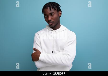 calm model dark-skinned young brunette man in a white sweater Stock Photo