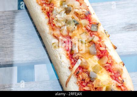 Hot Dog: A delightful hot dog filled with tasty pickles, fried onions, and a hint of tomato sauce, captured in a mouthwatering photo from above on a g Stock Photo
