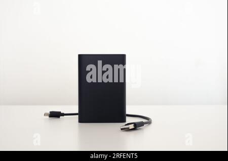 Portable black power bank with USB cable isolated on white background Stock Photo