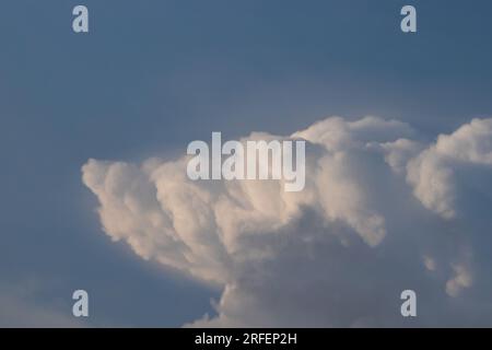 Clear blue sky at sunset, serene and peaceful scenery with clouds on horizon. Stock Photo