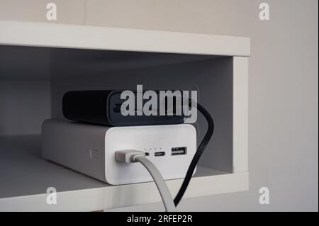 White power bank under black power bank. Chargers with black and white cables. In the table Stock Photo