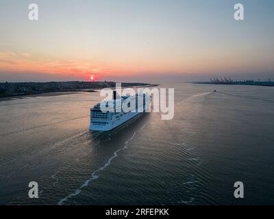 Norwegian Dawn cruise ship sails down the River Mersey at sunset, Liverpool, England Stock Photo