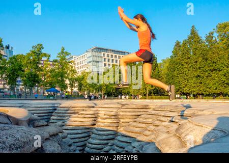 France, Paris, the Canyoneaustrate fountain at the foot of the Accor Arena omnisport palace (formerly Paris Bercy POPB), young tracers training in Parkour or Urban Art of Displacement (ADD) Stock Photo