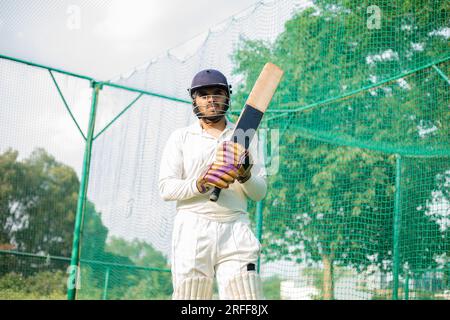 Cricket player is ready to practice batting in the nets during his ...