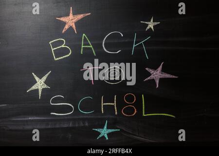 back to school text written on a blackboard by a chalk Stock Photo