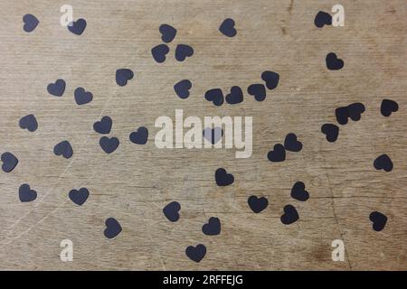 black paper confetti on a wooden table Stock Photo
