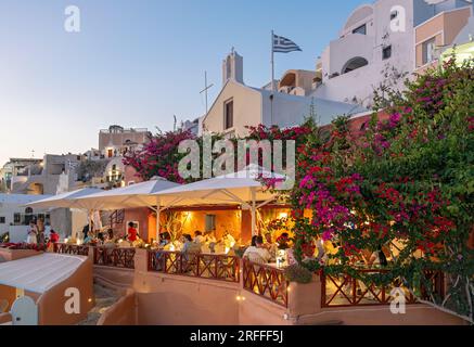 Greek restaurant at dusk, Oia castle, Ia, Santorini, Greece Stock Photo