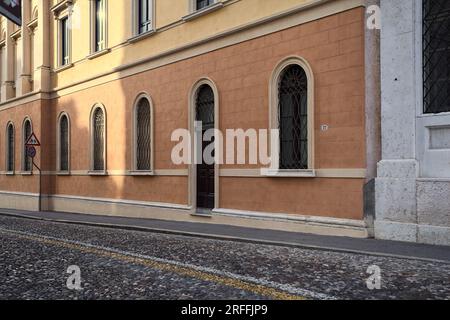 Wooden  doors of buildings on a cobbled street in an italian town at sunset Stock Photo