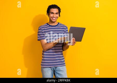 Photo of successful optimistic man wear trendy clothes use modern device netbook isolated on yellow color background Stock Photo