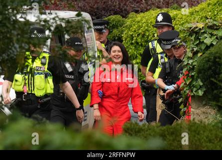 Greenpeace activists are led away by police after they climbed on the roof of Prime Minister Rishi Sunak's house in Richmond, North Yorkshire and covered it in black fabric in protest at his backing for expansion of North Sea oil and gas drilling. Picture date: Thursday August 3, 2023. Stock Photo