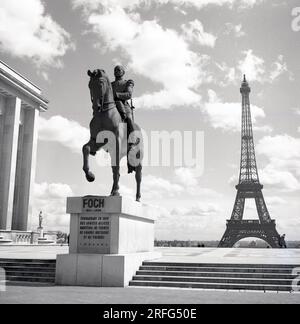 1950s, historical picture showing the satute of Ferdinand Foch (1851-1929) the Commandant in Chef of the Allied Forces during the closing months of WW1, with the famous Eiffel Tower in the background in Paris, France. Foch believed the Treaty of Versailles that ended the war, a treason. Stock Photo