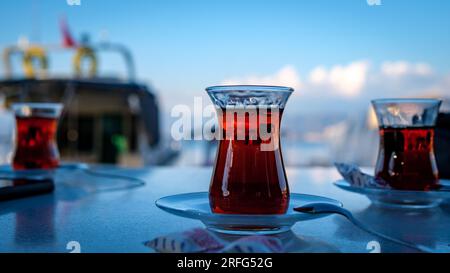 Turkish tea in glasses on the background of the sea and mountains, side view. Stock Photo