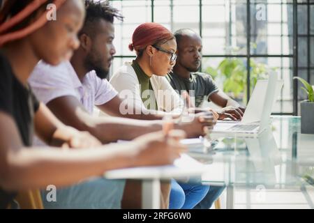Employees working at computer together, discussing content. Stock Photo