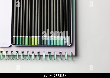 a set of coloring pencils and a notebook on a white background Stock Photo