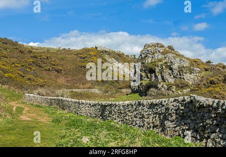The path down to Mewslade Bay from Pitton on a sunny April day with a beautifully built limestone wall all the way along to the coast and the beach Stock Photo