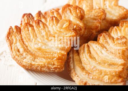 Fresh baked palmier puff pastry closeup on the plate on the table. Horizontal Stock Photo