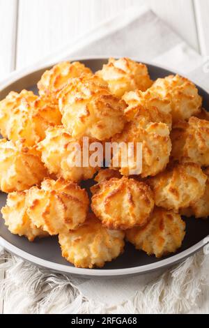 Coconut cookies macarons closeup on the plate on the table. Vertical Stock Photo