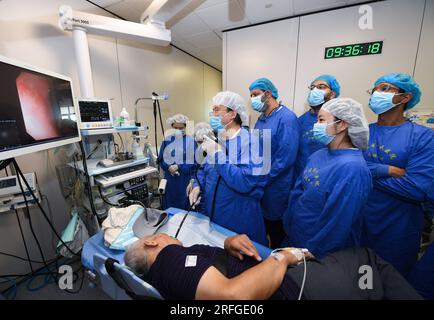 (230803) -- NANJING, Aug. 3, 2023 (Xinhua) -- Foreign medical workers of a medical seminar watch as Fan Zhining, expert of digestive endoscopy, performs an operation at digestive endoscopy center of Jiangsu Province Hospital in Nanjing, capital of east China's Jiangsu Province, Aug. 1, 2023. In recent years, Jiangsu Province Hospital cooperated with medical institutions in Pakistan, Egypt and other countries and regions in the field of digestive endoscopy to promote medical cooperation under the Belt and Road Initiative. (Xinhua/Ji Chunpeng) Stock Photo